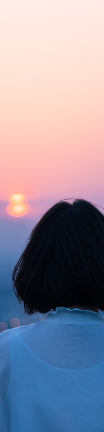 A woman with short hair, enjoying the beautiful sunset.