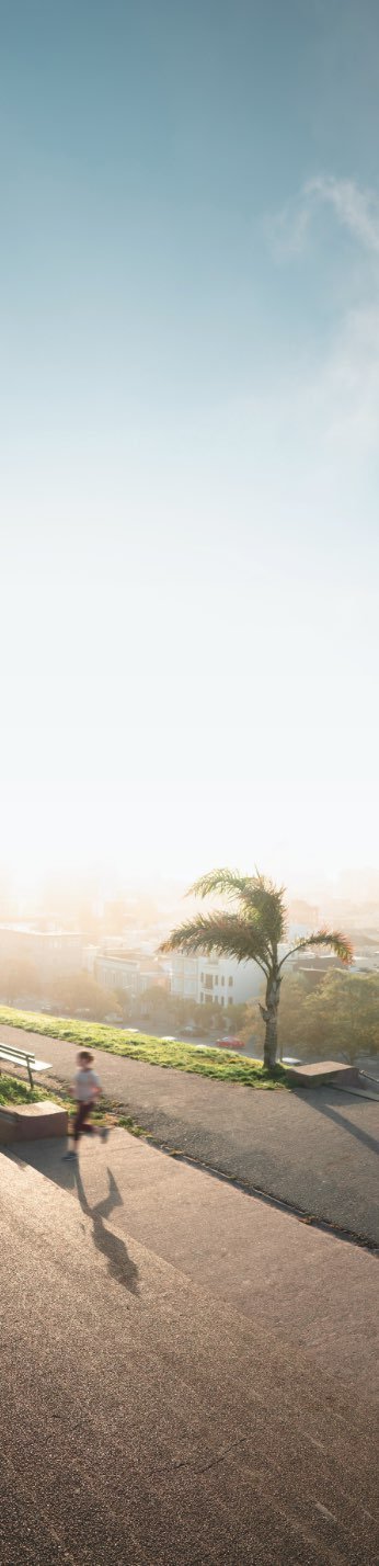 a man running across a street next to a palm tree